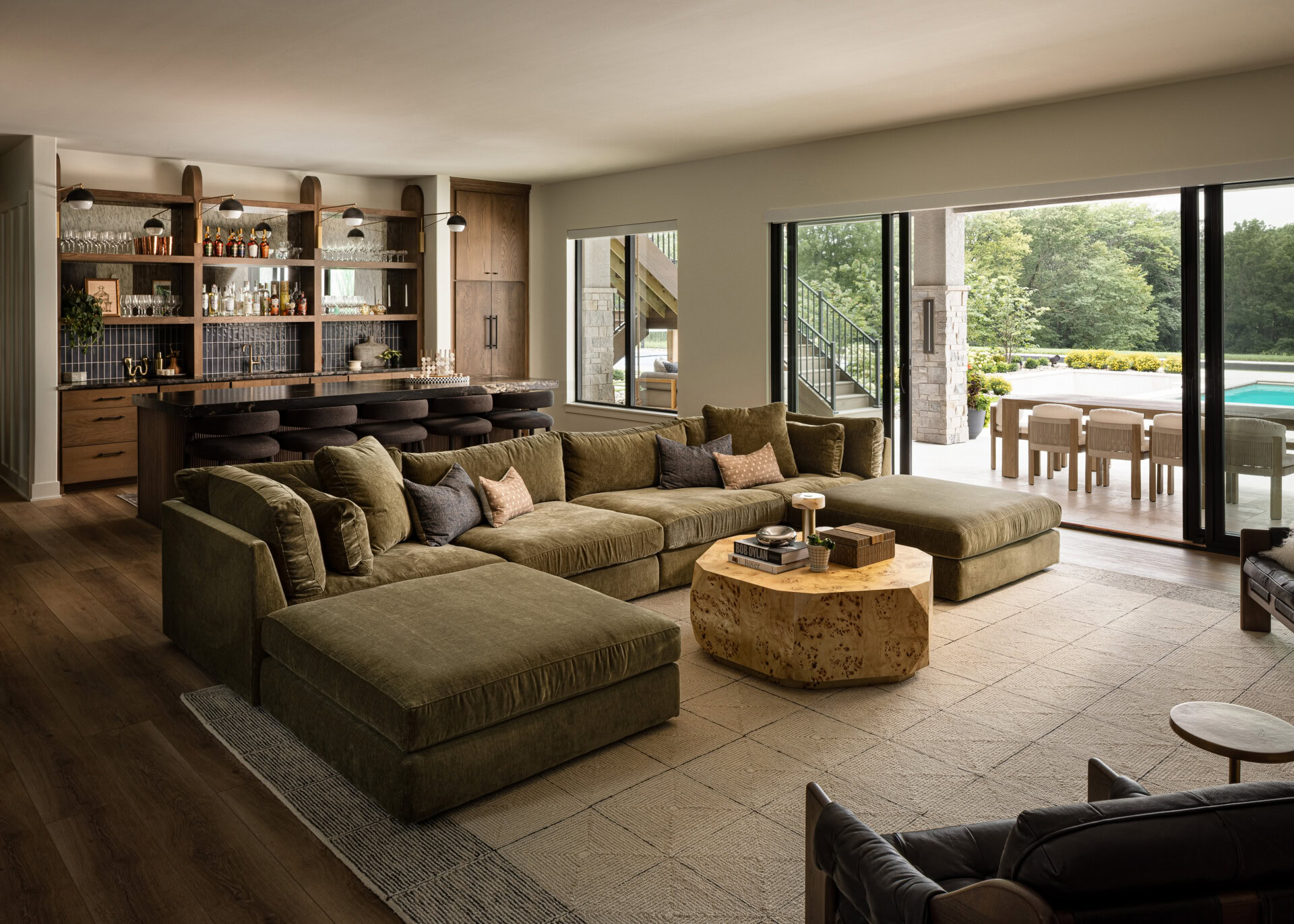 Modern Living Room with Pool View Spacious living room with large windows overlooking pool and outdoor seating area.